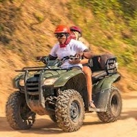 a group of people riding atvs down a dirt road